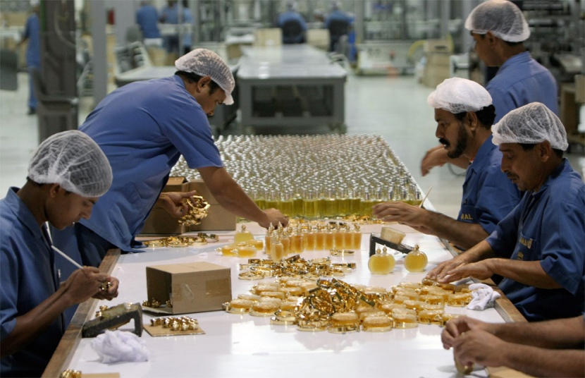 عمال يضعون اللمسات الأخيرة على زجاجات "عطور أجمل" في مصنعها في دبي.