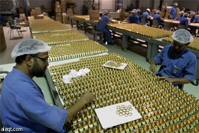 عمال يضعون اللمسات الأخيرة على زجاجات "عطور أجمل" في مصنعها في دبي.