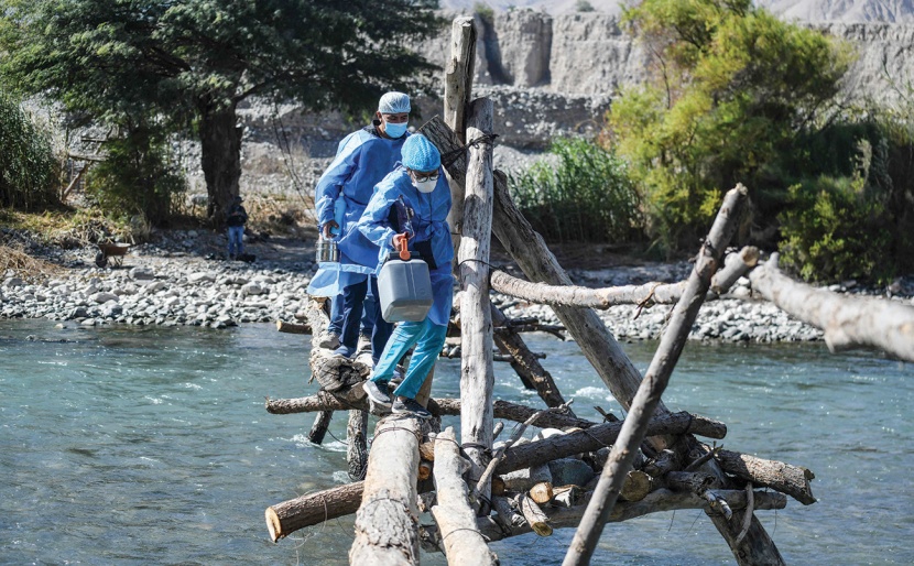 عاملون صحيون يعبرون نهر كامانا لتلقيح المواطنين المسنين بجرعات من لقاح كورونا في البيرو